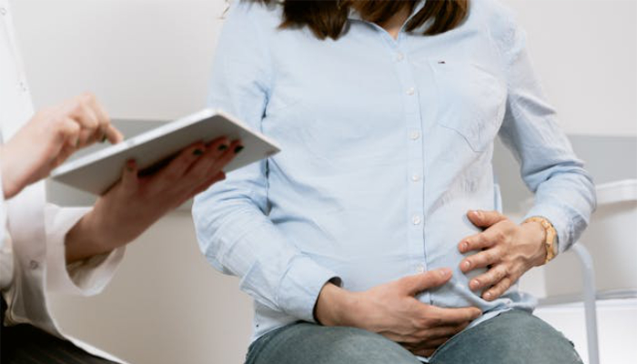 Pregnant woman sitting on a seat.