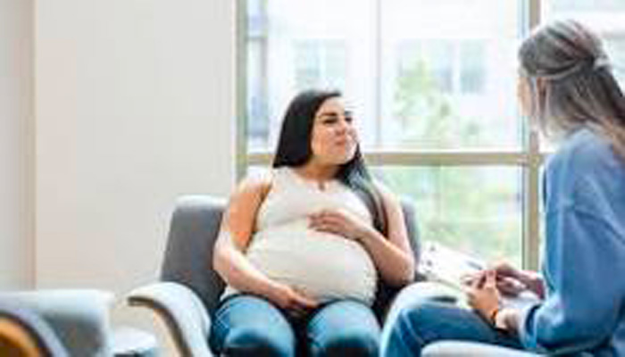 Pregnant woman sitting on a seat.